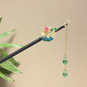 Close-up of a traditional Chinese black wooden hairpin with lotus enamel and pearl details