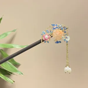 Intricate floral detail of a traditional Chinese sandalwood hairpin with pearl tassels