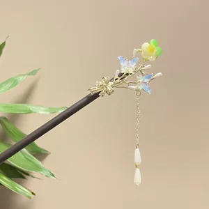Close-up detail of traditional Chinese wooden hairpin featuring blue butterflies and tassel