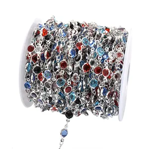 Gros plan d'une chaîne en verre multicolore de 6mm sur bobine pour création de bijoux.