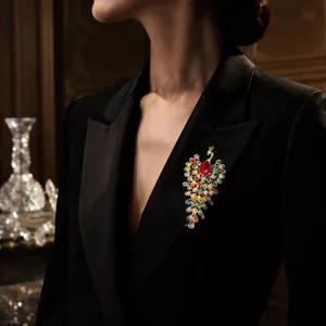 Vue rapprochée d'une broche paon luxueuse ornée de strass colorés sur un blazer noir.