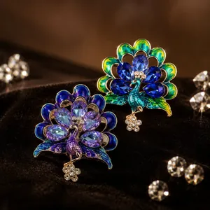 Gros plan de broches paon étincelantes avec des accents de cristaux bleus et violets