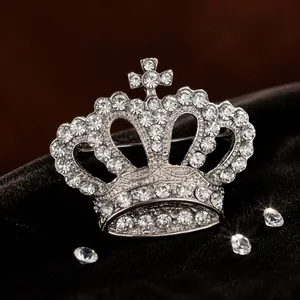 Elegant silver crown brooch encrusted with sparkling rhinestones on a black velvet background