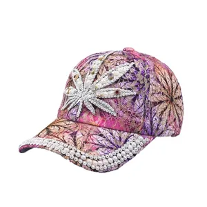 Detailansicht des Strass- und Perlenahornblattdesigns auf einer rosa Spitzenkappe.