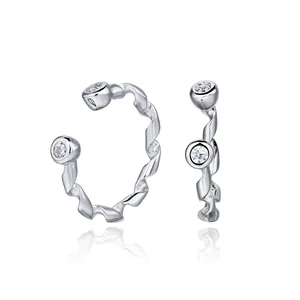 Detailed macro shot of twisted S925 sterling silver ear cuffs featuring clear gemstones.