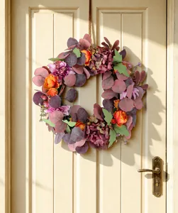 Artificial autumn wreath with peony and hydrangea hanging on a rustic wooden door