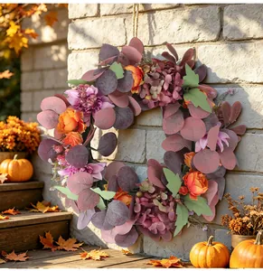 Decorative autumn wreath with artificial peonies and hydrangeas on a stone wall background