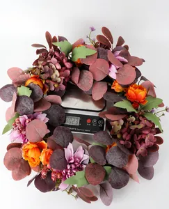 Detailed view of autumn floral wreath showing its 102.3g weight on an electronic scale