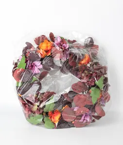 Close-up of artificial autumn peony and hydrangea wreath in clear protective plastic packaging