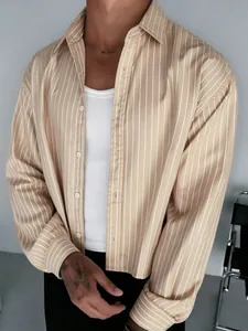 Detailed shot of a men's beige vertical striped long-sleeved shirt over a white tank top