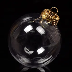 Macro detail of clear Christmas bauble with an ornate gold cap on black background