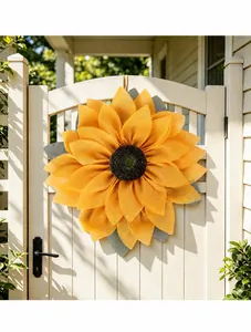 Detailed view of a vibrant yellow sunflower mesh wreath on a white gate