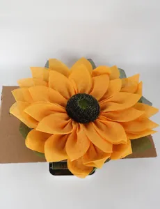 Detail view of large yellow fabric sunflower wreath showing weight on a digital scale