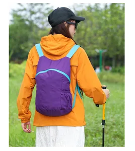 Macro detail of the purple hiking backpack worn by a model in an outdoor park setting