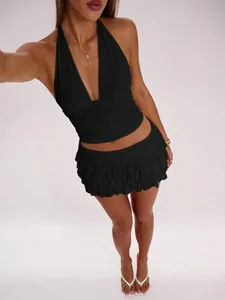 Close-up of elegant black halter neck top and layered ruffled mini skirt set for women