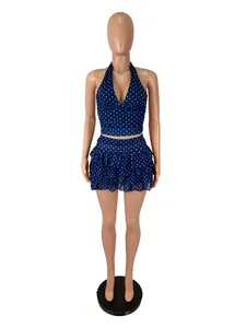 Full frontal display of navy polka dot halter crop top and layered ruffle mini skirt set