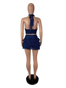 Back view of a navy blue polka dot halter top and ruffled mini skirt set on a mannequin