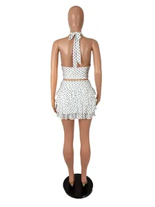 Back view of a white polka dot halter crop top and tiered ruffle mini skirt set.