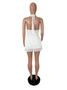Back view of a white halter crop top and tiered ruffled mini skirt set on mannequin