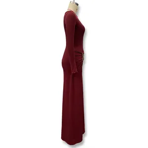 Side view of a slim fit burgundy maxi dress with gold metal waist ornament on a mannequin