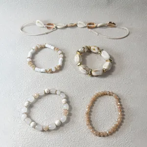 Conjunto bohemio de pulseras de cuentas y tobillera de conchas en tonos crema y oro