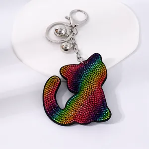 Detalle de un llavero de gato con diamantes de imitación arcoíris y cascabeles plateados.