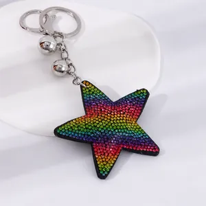 Detalle de un llavero de estrella con diamantes de imitación degradados y campanas