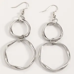 Close-up detail of silver irregular double hoop earrings with minimalist geometric design