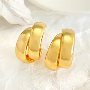 Macro view of minimalist double-layered chunky gold hoop earrings with mirror polish finish