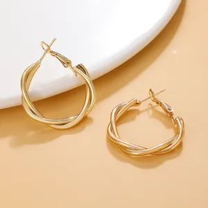 Close-up of elegant gold twisted hoop earrings with a polished metallic finish.