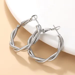 Detail shot of elegant silver twisted hoop earrings featuring a polished metallic finish