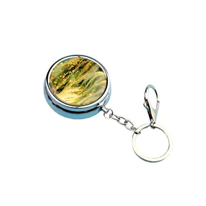 Portable metal mini pill box keychain featuring a decorative golden abstract art design