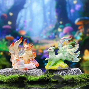 Close-up of two colorful Nine-tailed Fox figurines on mossy rocks in a magical forest