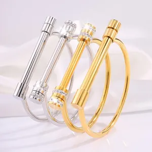 Detailed view of polished titanium steel bangles with sparkling crystals in gold and silver