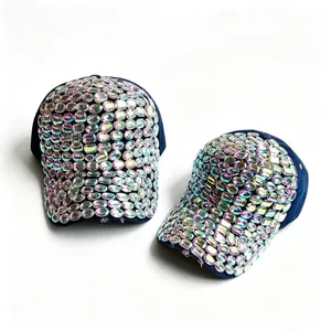 Detailed view of two navy baseball caps fully embellished with iridescent oval rhinestones.