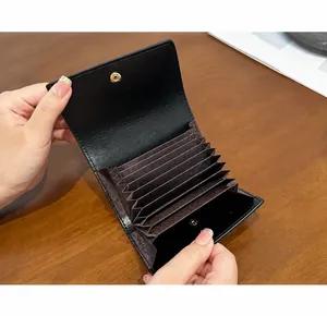 Vista interna dettagliata di un portacarte in pelle nera con scomparti a fisarmonica.