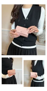 Vista dettagliata di un portafoglio minimalista intrecciato rosa tenuto da una modella.