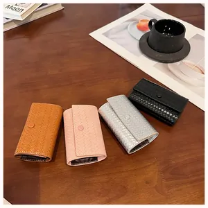 Vista dettagliata di mini portafogli intrecciati in vari colori su tavolo di legno