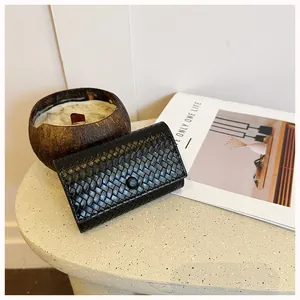 Vista dettagliata del portafoglio clutch in pelle intrecciata nera con bottone