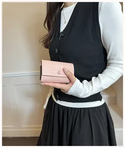 Vista dettagliata del portafoglio rosa intrecciato tenuto da una modella stile chic