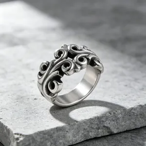 Vintage punk titanium steel ring with hollowed scroll pattern on textured stone background.