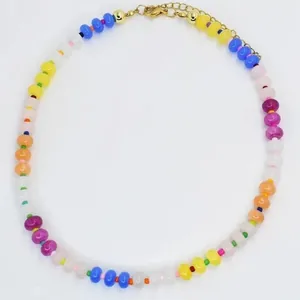 Λεπτομερής λήψη ενός κολιέ με χάντρες στα χρώματα του ουράνιου τόξου και χρυσό κούμπωμα