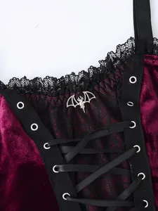 Close-up view of a gothic purple velvet camisole with black lace and silver bat charm