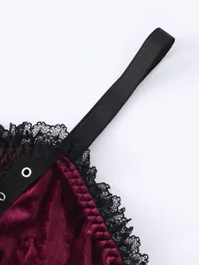 Close-up of black lace trim and burgundy velvet on a gothic camisole top strap