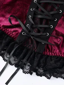 Close-up of gothic burgundy velvet corset top with black lace-up ribbons and lace trim detail.