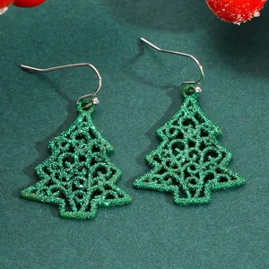 Detailed view of green glitter Christmas tree earrings with intricate cutouts
