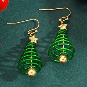 Detailed macro shot of creative green wire spiral Christmas tree earrings with gold star accents