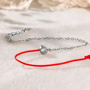 Detailaufnahme eines Armbands aus roter Kordel und Edelstahl mit Zirkonia