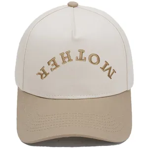 Close-up of the inverted MOTHER embroidery on a two-tone beige and khaki baseball cap