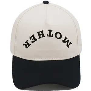 Close-up of beige and black baseball cap with upside down MOTHER embroidery detail.